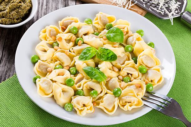 istock tortellini with green peas, fried Pine nuts,  top view 517667902