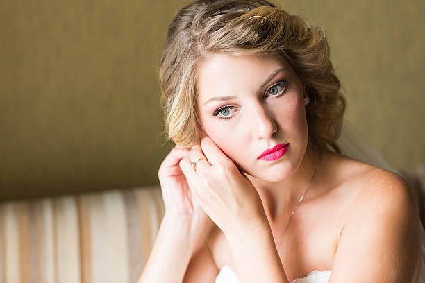 istock Beautiful elegant bride putting on earrings closeup, wedding preparation 517668196