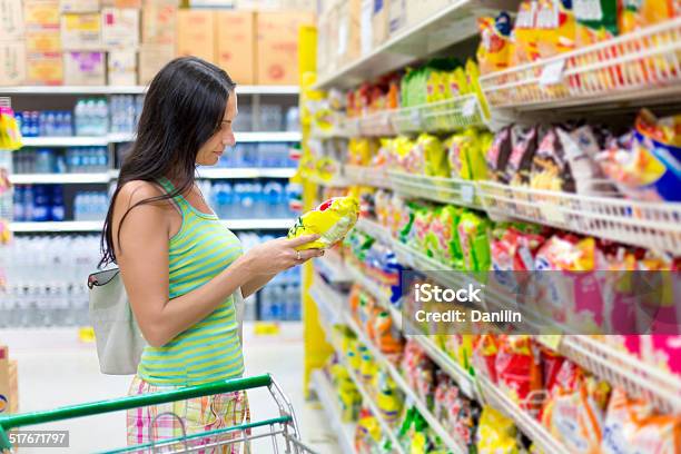 Photo libre de droit de Femme Achète Des Chips Dans Le Magasin banque d'images et plus d'images libres de droit de Chips de pomme de terre - Chips de pomme de terre, Supermarché, En-cas