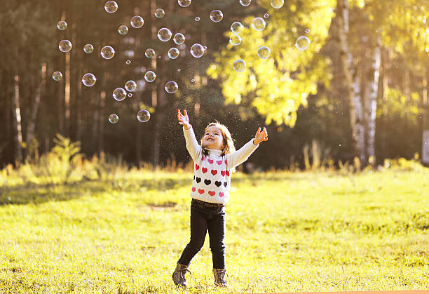istock Little child having fun with bubbles soap autumn 517678489