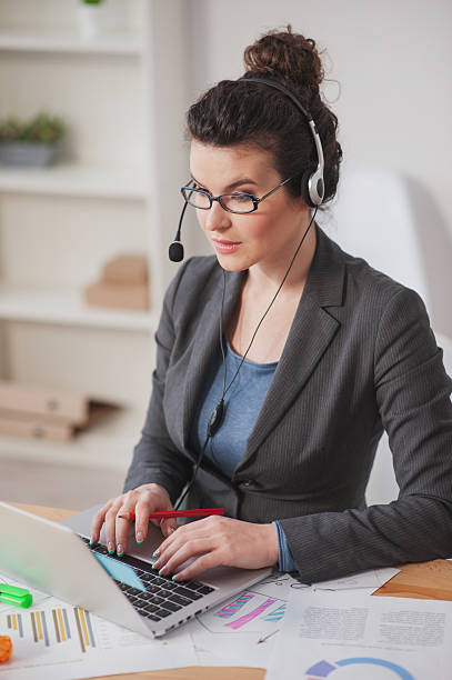 istock Attractive female operator of call center in office 517680292