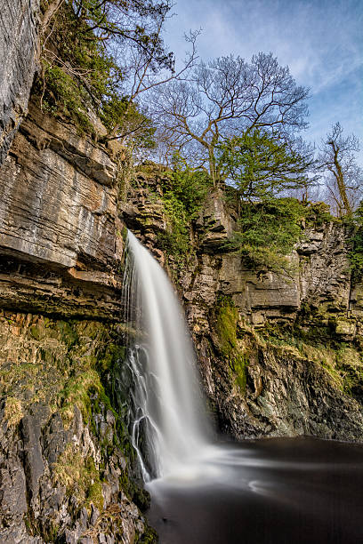 istock Huge Flowing Waterfall With Blue Sky And Trees. 517682296