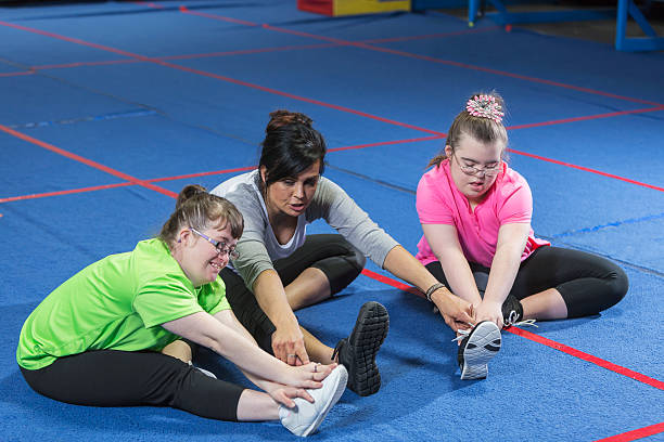 istock Fitness instructor working with special needs girls 517683898