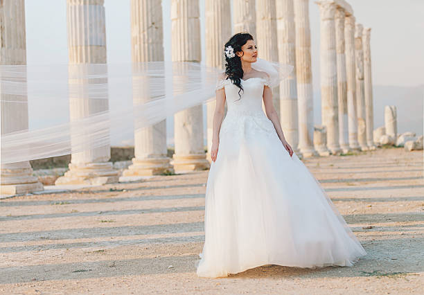 Beautiful bride in wedding dress posing at ancient city