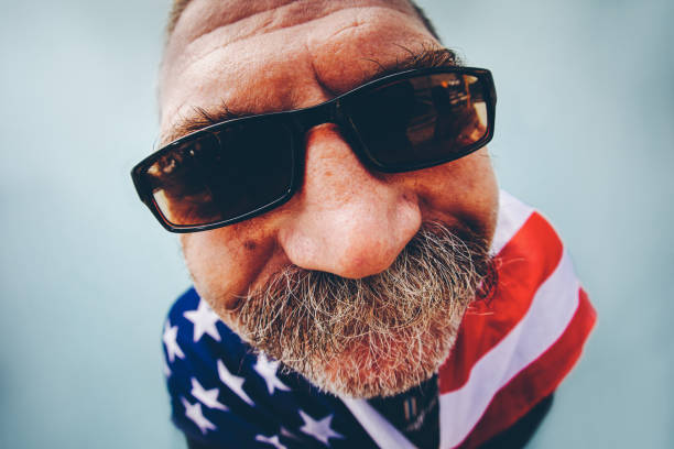back view of man in jeans holding american flag on roof