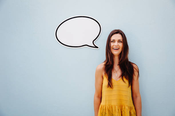 istock Cheerful pretty middle-aged woman smiling with speech bubble 517690494