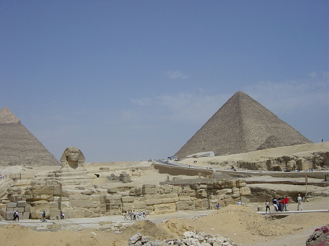 Pyramids of Giza, Giza Necropolis, Egypt - July 26, 2022: The Giza Necropolis is a large area near Giza, a suburb of Cairo that has many tombs and burial sites. It is also where you can find the famous Pyramids of Giza, the Great Sphinx, and more. The name comes from the ancient Greek word nekropolis, which literally means “city of the dead”.\n\nThe Giza Complex was once near the ancient Egyptian capital of Memphis, and the Giza plateau is where a number of pharaohs, queens, and nobles of the Fourth Dynasty of ancient Egypt were buried. \n\nAll three of Giza's pyramids and their elaborate burial complexes were built  from roughly 2550 to 2490 B.C. The pyramids were built by Pharaohs Khufu, Khafre, and Menkaure.