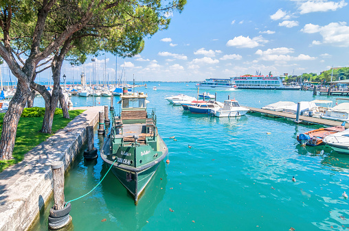 Desenzano, Italy - May 18, 2014: small harbor with boat in Desenzano on lake Garda, Italy. Desenzano is one of the most popular cities visited by tourists every summer.