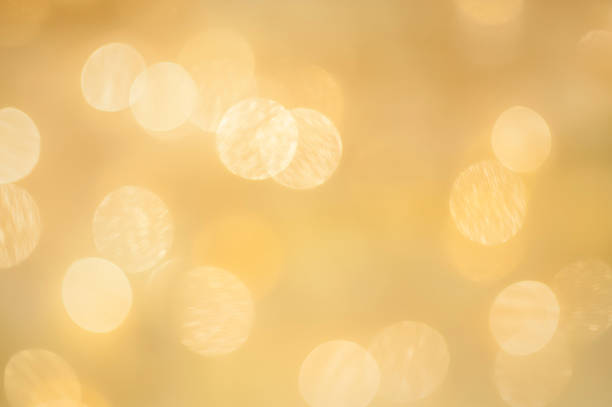 Background of glittering golden defocused lights.  Light points have some metallic texture for a confetti effect.