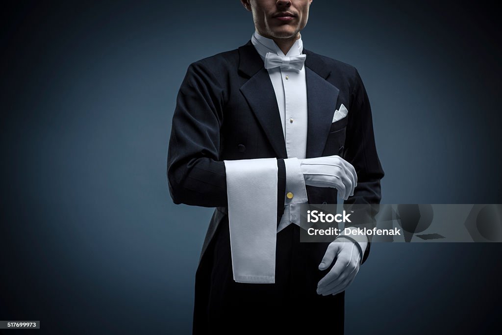 Waiter Waiter in a tuxedo on a black background White Color Stock Photo