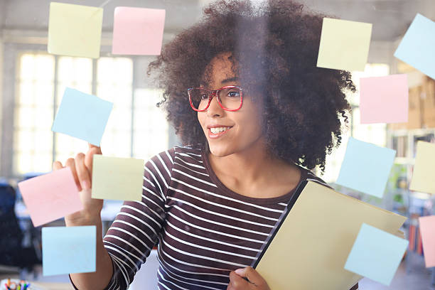 istock Cheerful woman looking at window with sticky notes 517701552