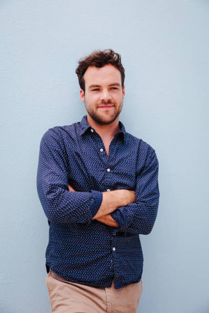 istock Good looking young man against blue wall 517704894