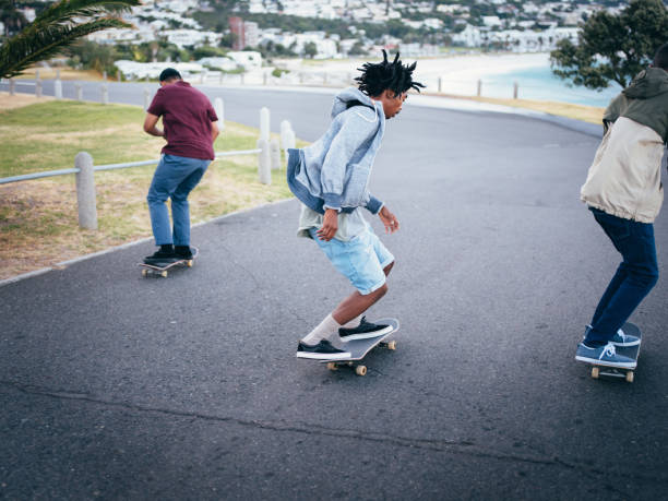 istock Multi-Ethnic Group of Skaters Skating Down Street at Beach 517706436