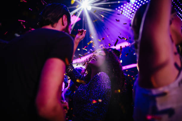 jóvenes amigos divirtiéndose con confeti en el fiesta club de noche - discoteca fotografías e imágenes de stock