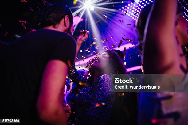Young Friends Having Fun With Confetti On Night Club Party Stock Photo - Download Image Now