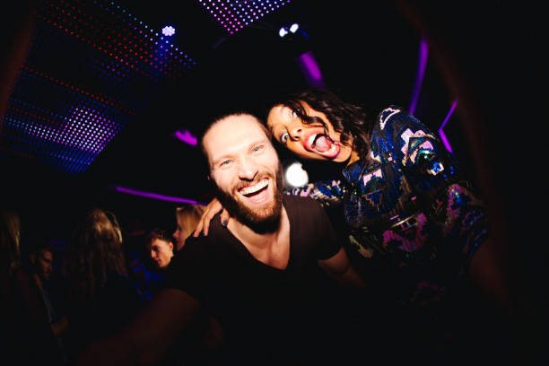 istock Cheerful young couple having fun with selfie at disco 517709390