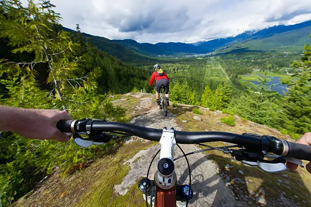 POV image of a mountain biker following another biker on a trail