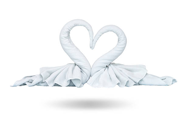 Two white towels swans with heart on white background