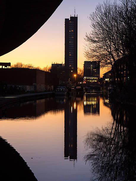 Trellick Tower The brutalist concrete Trellick Tower block  in West London reflected in the Grand Union Canal at sunset. trellick tower stock pictures, royalty-free photos & images