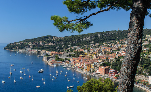 Wide angle high level panorama of Villefranche bay, Nice, Cote d'Azur, France, showing Mont Boron to the West, with the clear  turquoise meditaerannean sea in the bay under a clear blue sky