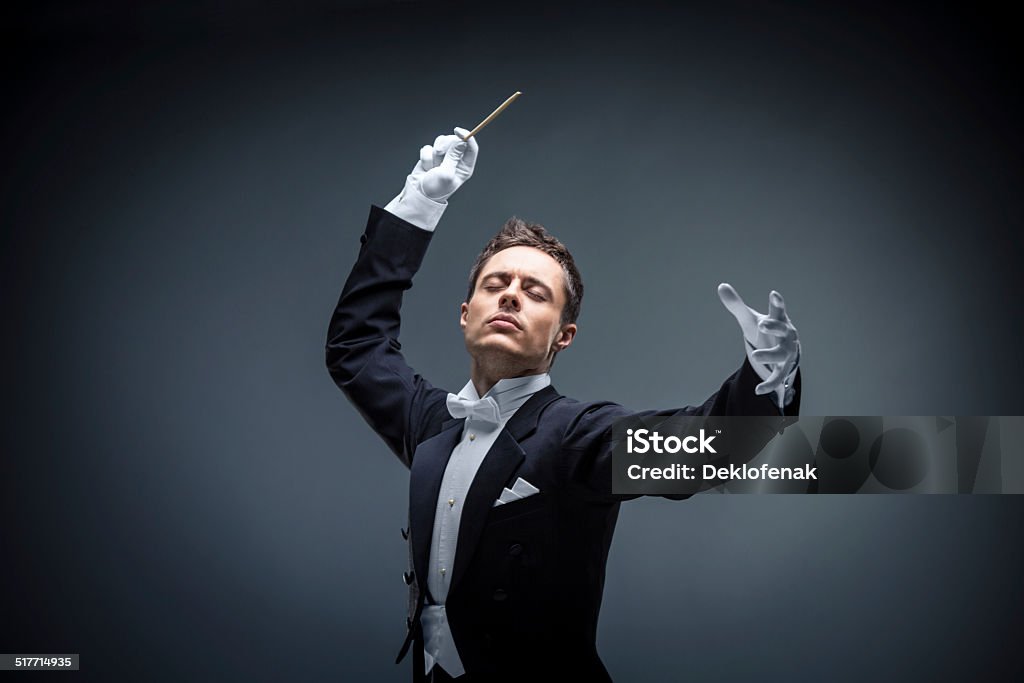Composer Young man in tuxedo conducting Musical Conductor Stock Photo