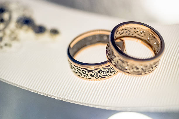 istock Two wedding rings with rare design on white broad ribbon 517715052