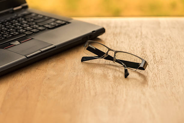 istock Laptop and glasses on wood table 517715332