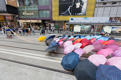 Hong Kong, Hong Kong SAR - October 11, 2014: An umbrella installation in Causeway Bay. People walk on a blockaded road in Causeway Bay, Hong Kong. Occupy Central is a civil disobedience movement which began in Hong Kong on September 28, 2014.
