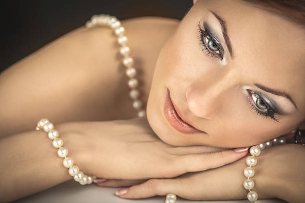 Beautiful pearl necklace on red silk, closeup