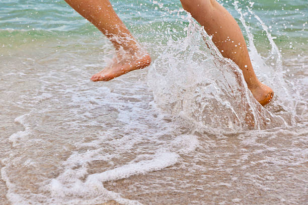 istock feet of boy running along the beach 517728259