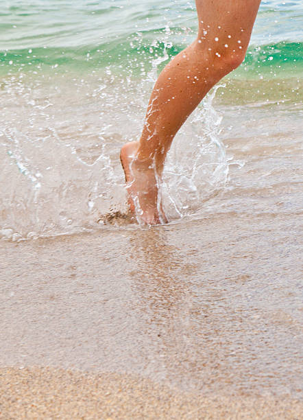 istock feet of boy running along the beach 517728263