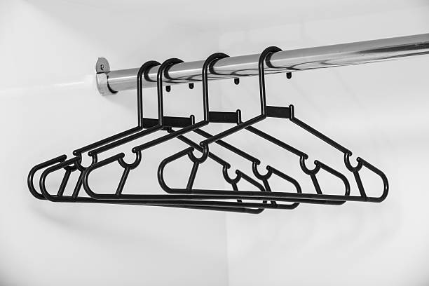 coat hanger black plastic coat hanger on bar clothes hanger rod stock pictures, royalty-free photos & images