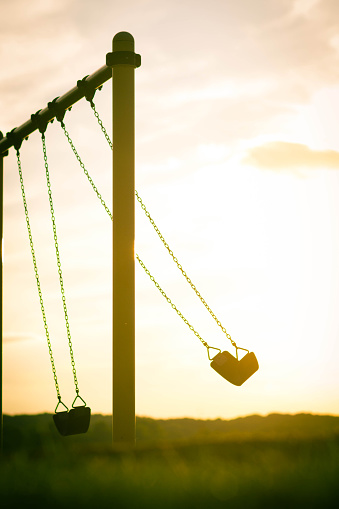 An empty swing in the sunset