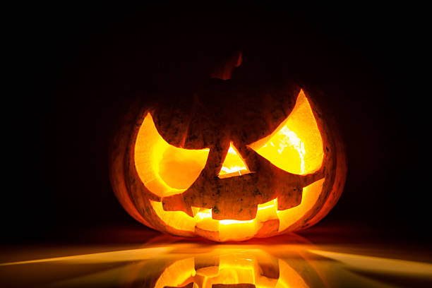 istock Halloween scary face pumpkin on black background 517729241