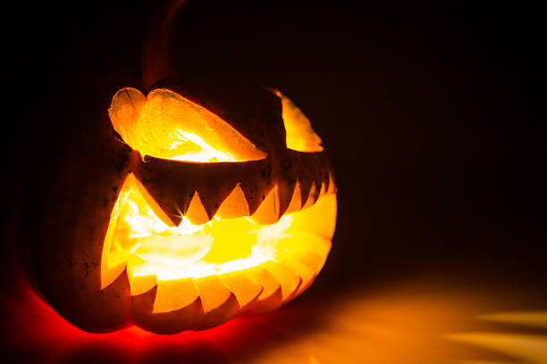 istock Halloween scary face pumpkin on black background 517729249