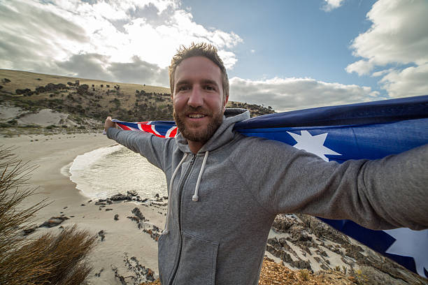 istock Young man on beach holding Australian's flag 517738298