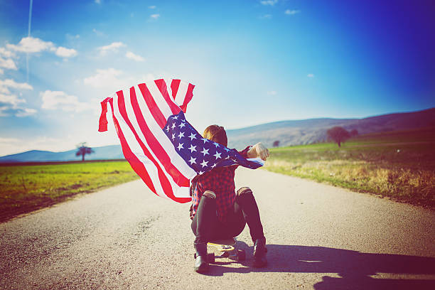 istock Female longboarder flying an American flag 517738518