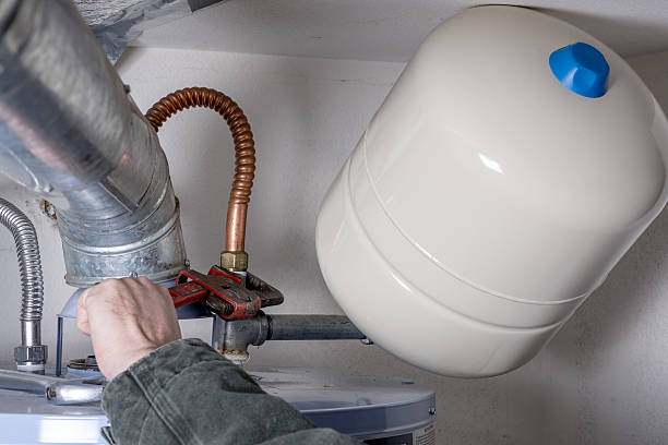 istock Man works on hotwater heater with wrench 517740080