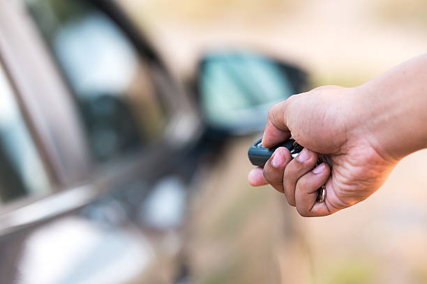 homme main en poussant le bouton de débloquer voiture avec télécommande - car car rental car dealership key photos et images de collection