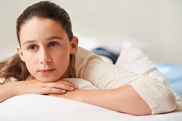 Weight of the world Shot of a teenage girl lying on her bed looking thoughtful 13 14 years child teenage girls lying down stock pictures, royalty-free photos & images