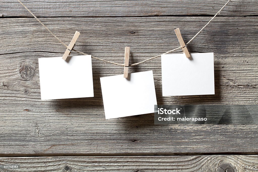 Blank photos hanging Blank photos hanging from a rope on a wooden background. Hanging Stock Photo