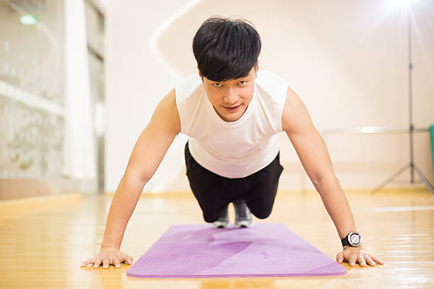 istock young handsome asian man works out in modern gym 517749784