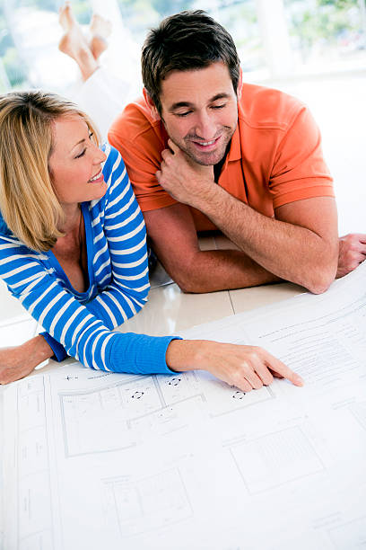 istock Happy couple pointing at blueprints 517749801