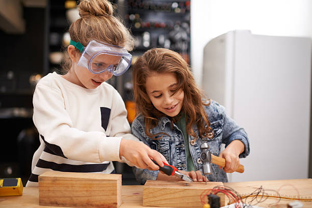Playing with dads tools is the best! Shot of two little girls busy at work on creating something with tools girl with a hammer stock pictures, royalty-free photos & images