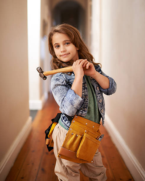 She can fix it Portrait of a young girl wearing a tool belt and holding a hammer girl with a hammer stock pictures, royalty-free photos & images