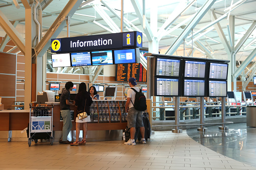 Vancouver, BC Canada - September 13, 2014 : People asking some information insdie the YVR airport in Vancouver BC Canada.