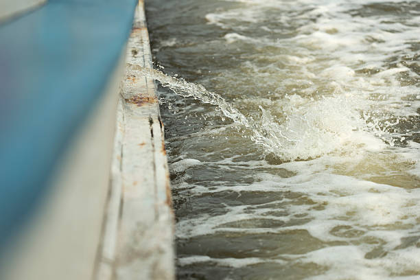 Shallow DOF of bilge pumped out Shallow DOF of bilge being pumpt out of boat splashing into sea while boat is moving bilge of ship stock pictures, royalty-free photos & images