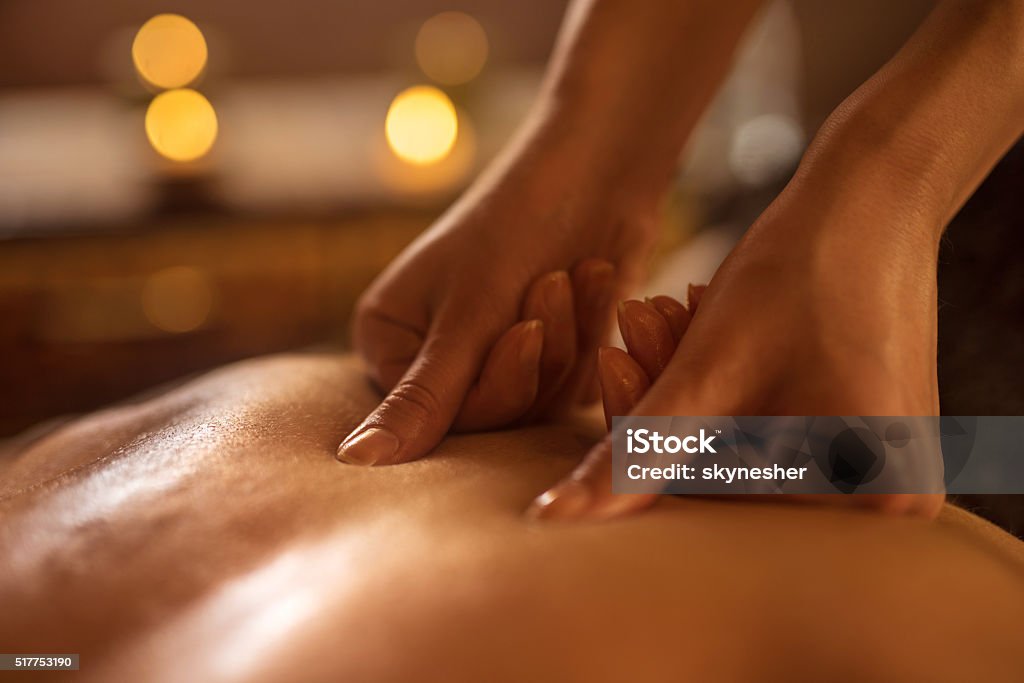 Close-up of alternative therapy at the spa. Close-up of massage therapist applying pressure on man's back at the spa. Massaging Stock Photo