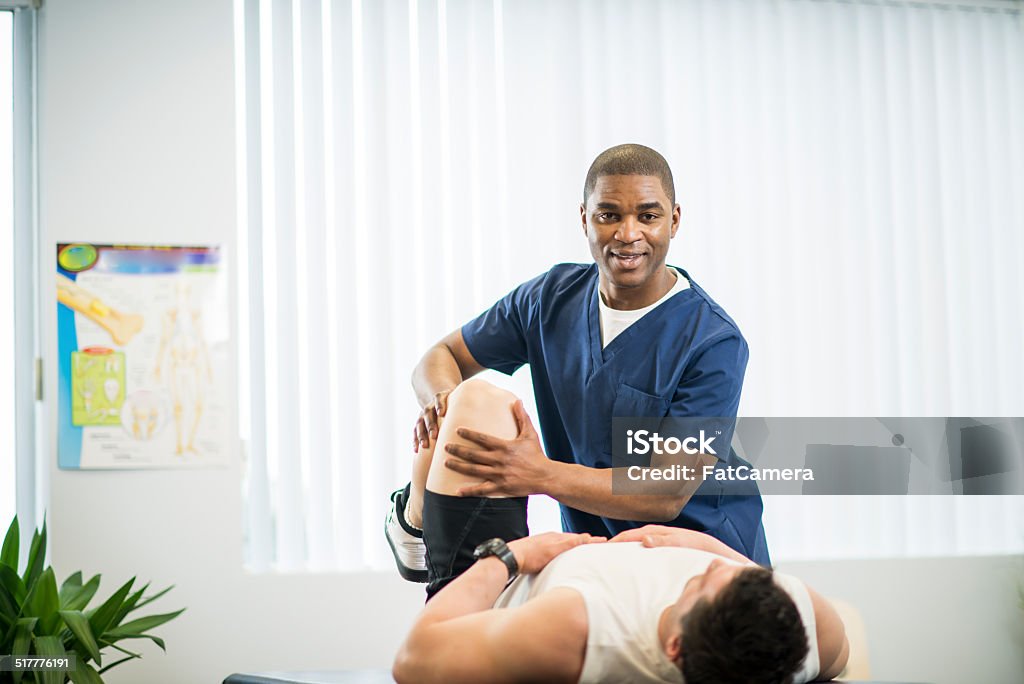 Physical Therapy An athlete receiving rehibilitative care for a sports injury. Adult Stock Photo