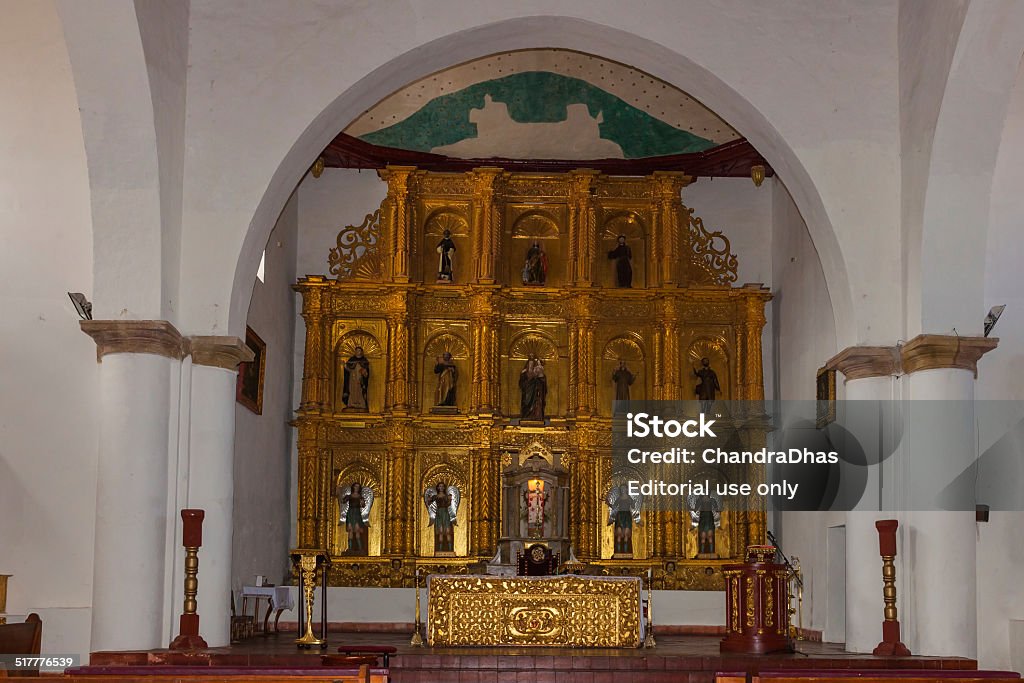 Villa de Leyva, Colombia - Interior of old church Villa de Leyva, Colombia - September 14, 2014: The guilded main altar in the interior of the old church on the main plaza in the old Andean town of Villa de Leyva, in the Department of Boyaca of the South American country of Colombia. Photo shot from the front of the church. It is Sunday morning, but right now there is no mass taking place; and photographs are allowed inside the church.  It is constructed in the classical, colonial Spanish type of architecture and is over 400 years old. Horizontal format. Boyacá Department Stock Photo